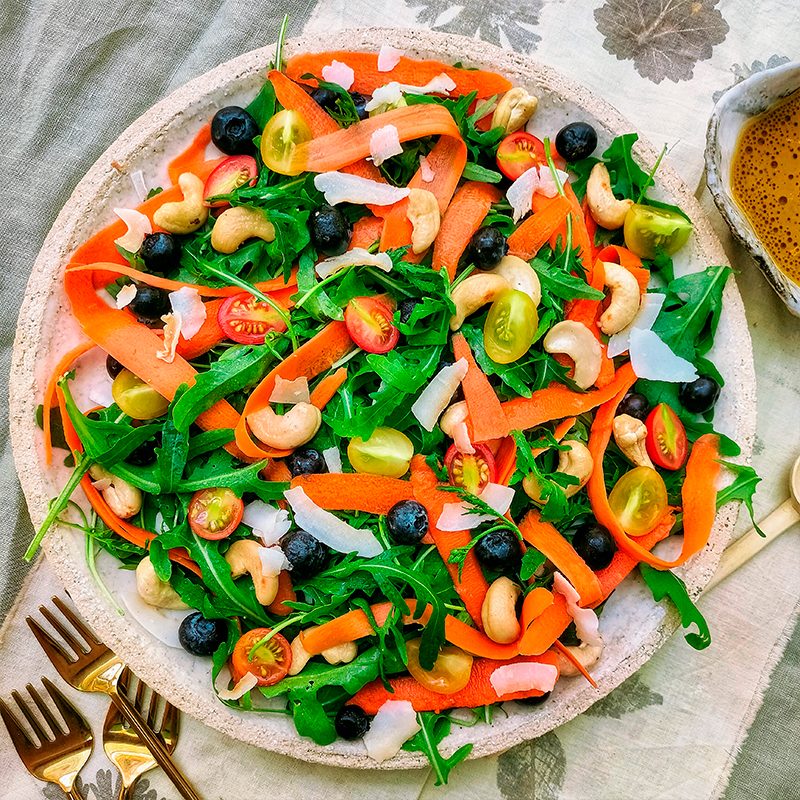 Ensalada de rúcula con arándanos, anacardos y coco